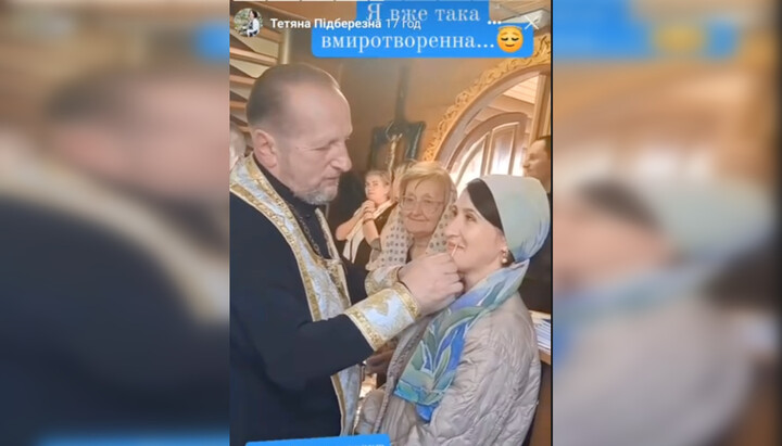 Клирик ПЦУ Николай Хомяк с прихожанкой. Фото: скриншот видео