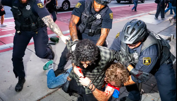 Police officers try to separate two men fighting in California during a TPUSA event in memory of Charlie Kirk. Photo: NY Post